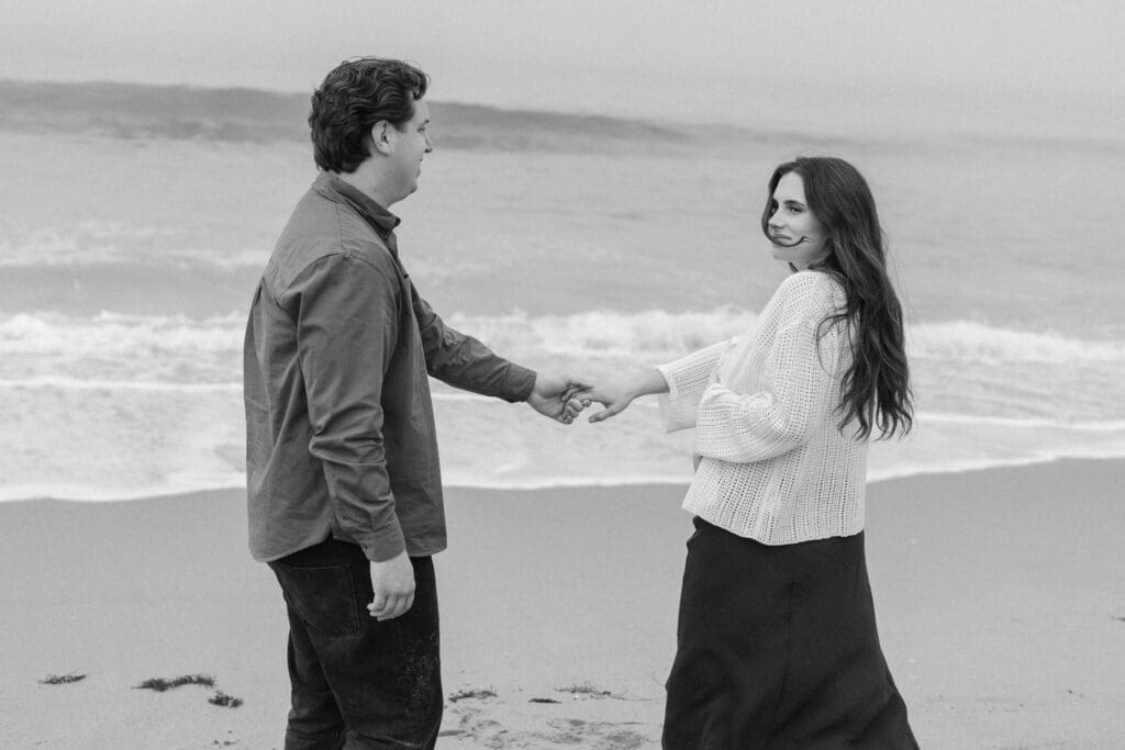 Beach maternity session with kids – mom and dad hugging toddler at sunset in San Clemente
