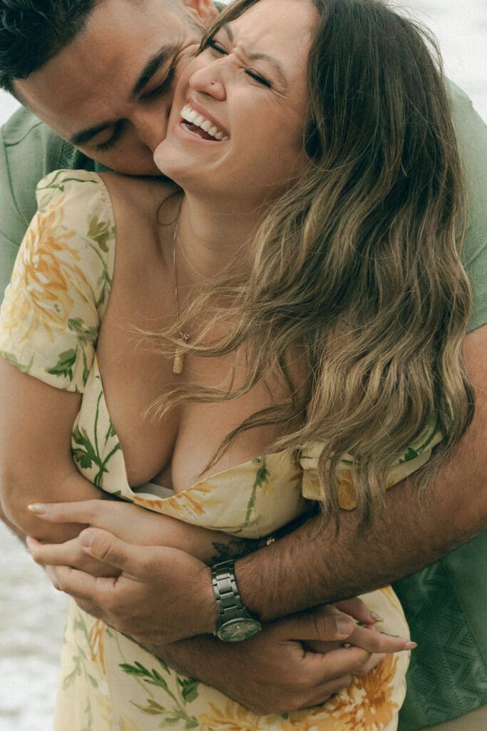 What to wear for your beach engagement session in Laguna Beach: bride-to-be’s dress blowing in wind on beach