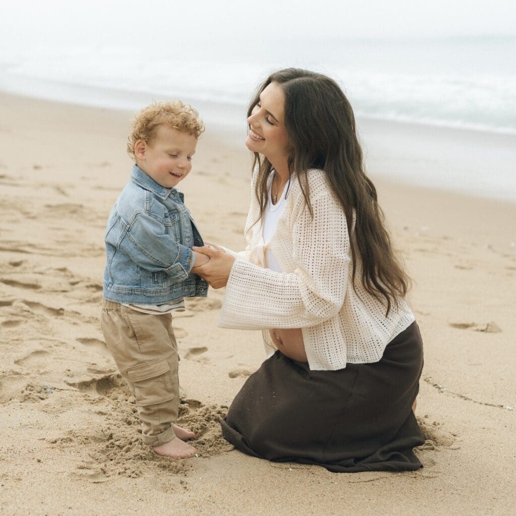 Parents kneeling to talk with kids before starting playful beach photos