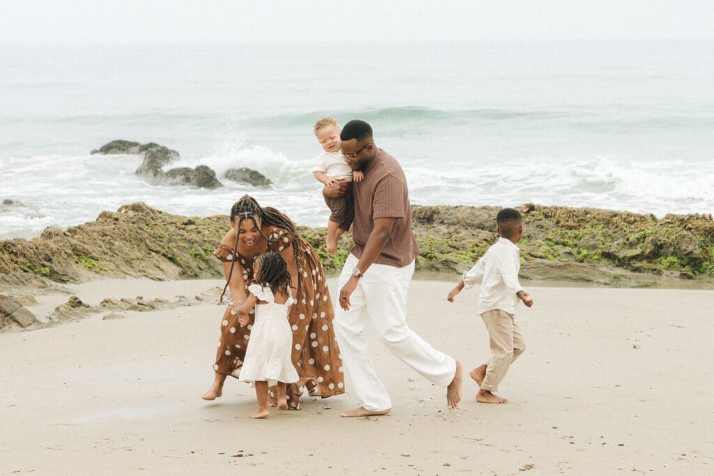Kids running toward the waves at Laguna Beach during morning family photos