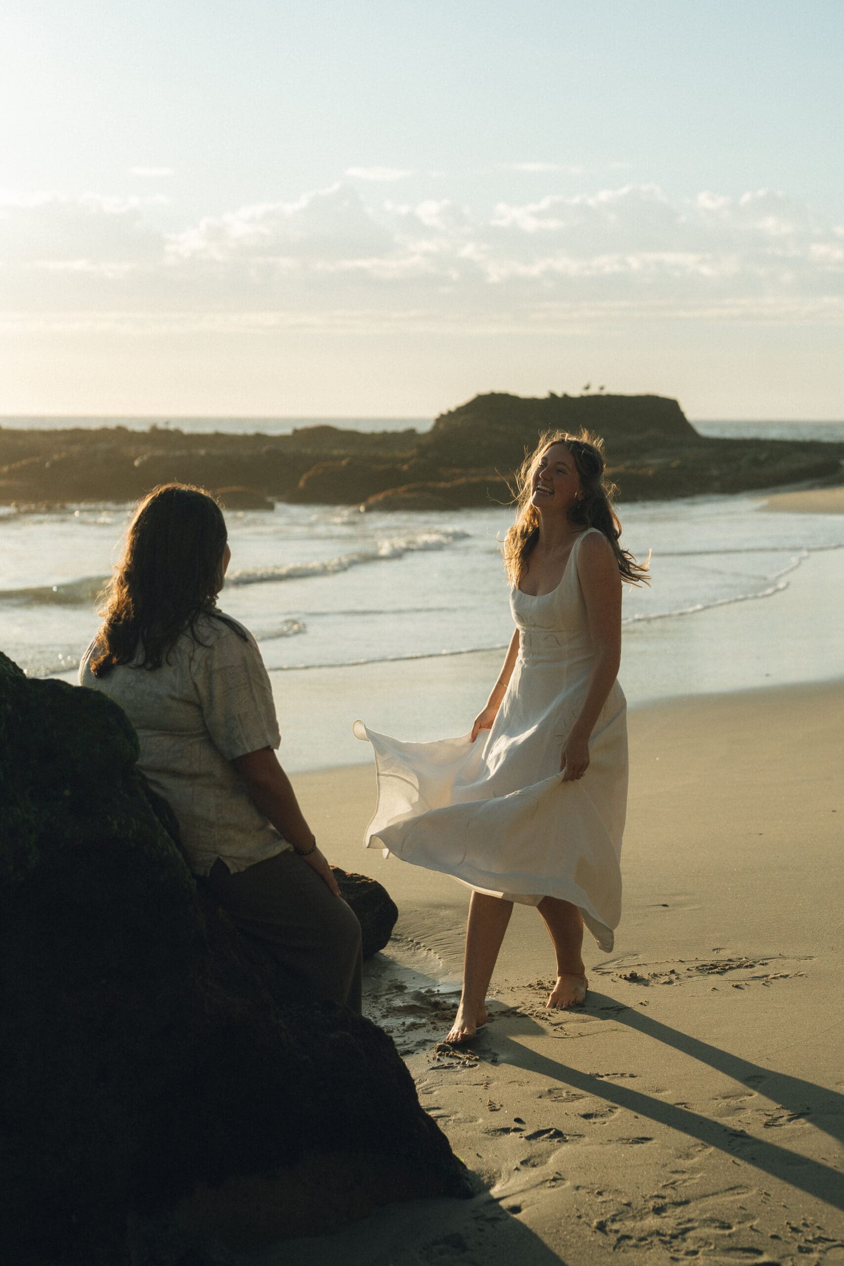 LGBTQ couple sharing a kiss during golden hour beach proposal in SoCal