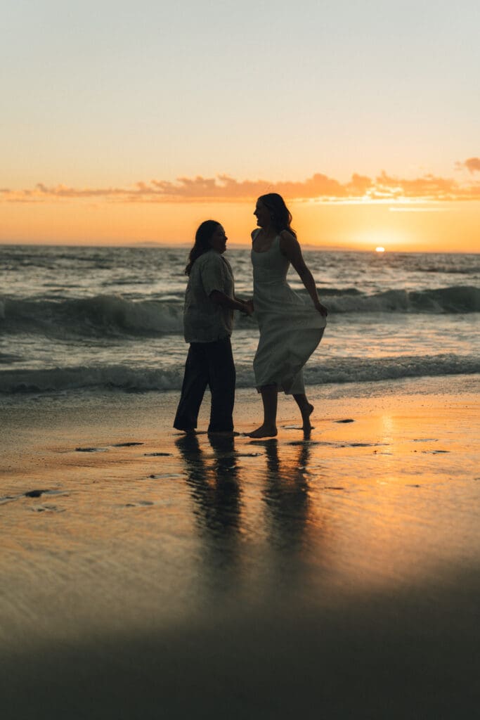 Intimate proposal moment surrounded by ocean waves and golden light